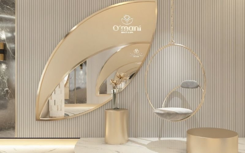 Nội thất spa sang trọng với ghế treo tròn, bàn tròn và bình hoa trên nền tường sọc đứng tinh tế.