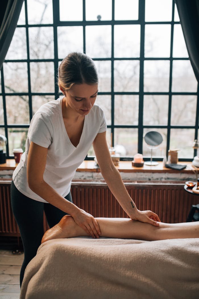 A woman provides a calming foot massage in a tranquil indoor space, promoting relaxation and well-being.